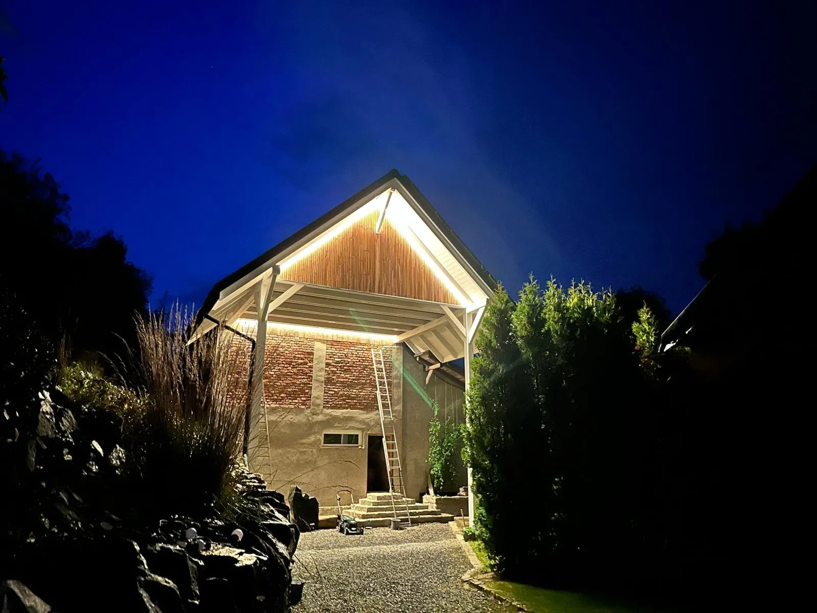 Gotowa wiata po zmroku, z podświetleniem podkreślającym formę i skalę konstrukcji.