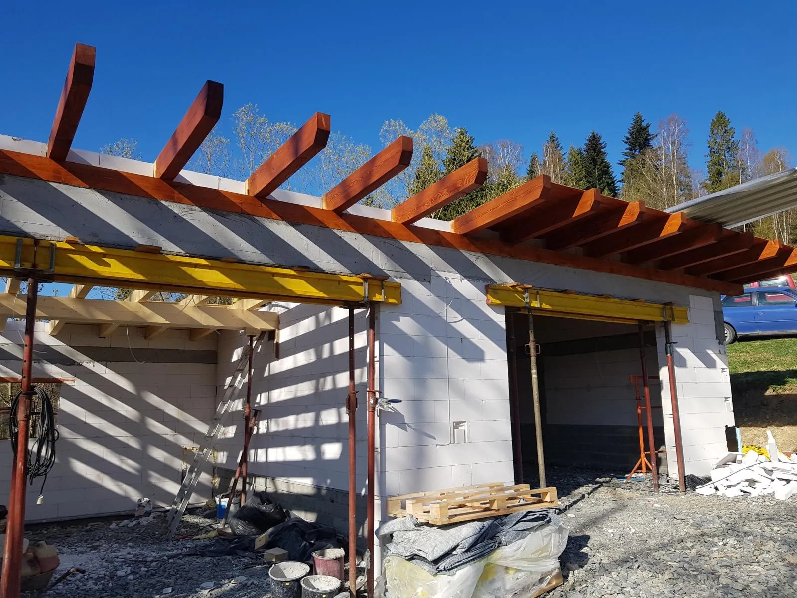 Zadaszenie garażu w trakcie montażu, z dobrze widocznym układem belek i wysięgów.