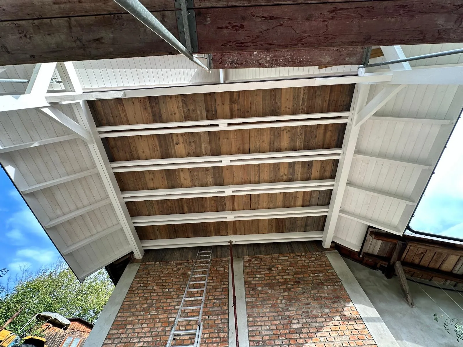 Spód gotowej wiaty z równym układem belek i starannie wykończoną drewnianą podsufitką.