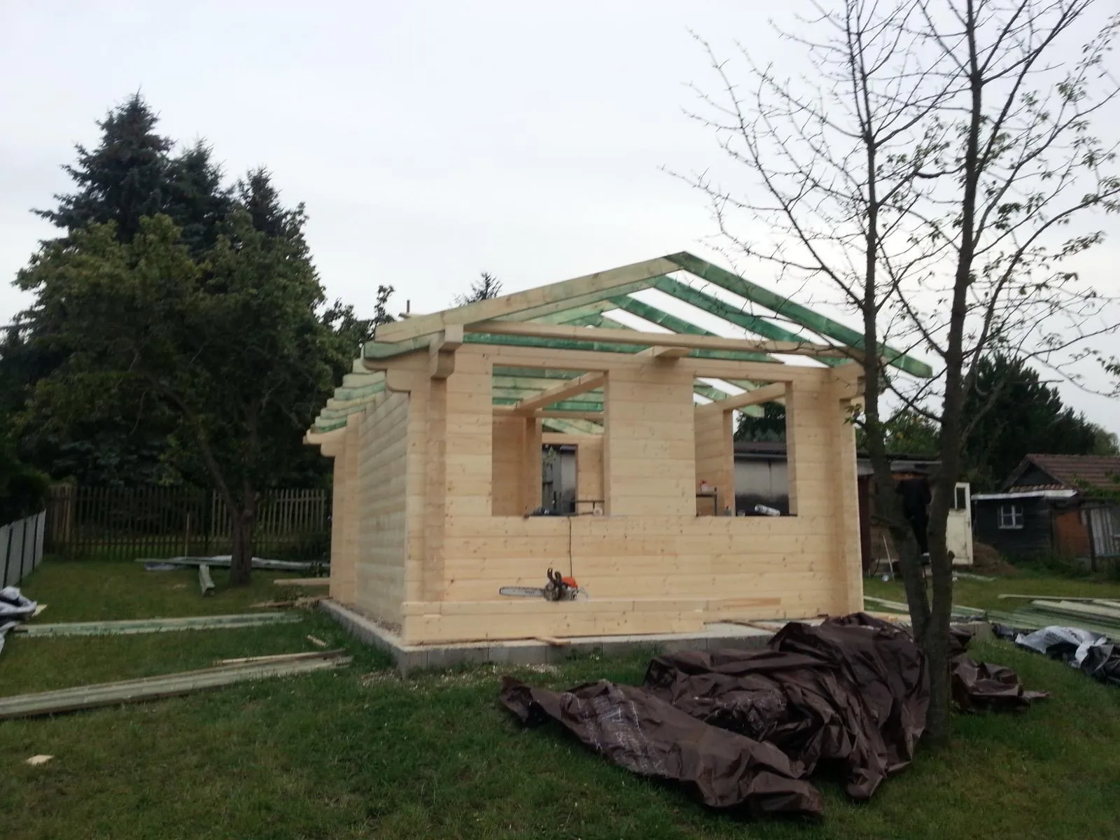 Stan po ustawieniu ścian i przygotowaniu konstrukcji dachu do kolejnych etapów prac.