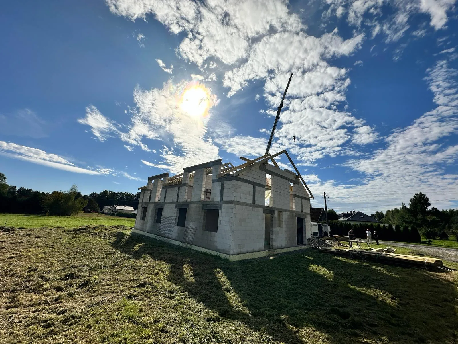 Boczna strona budynku z widocznym postępem montażu krokwi i elementów nośnych.