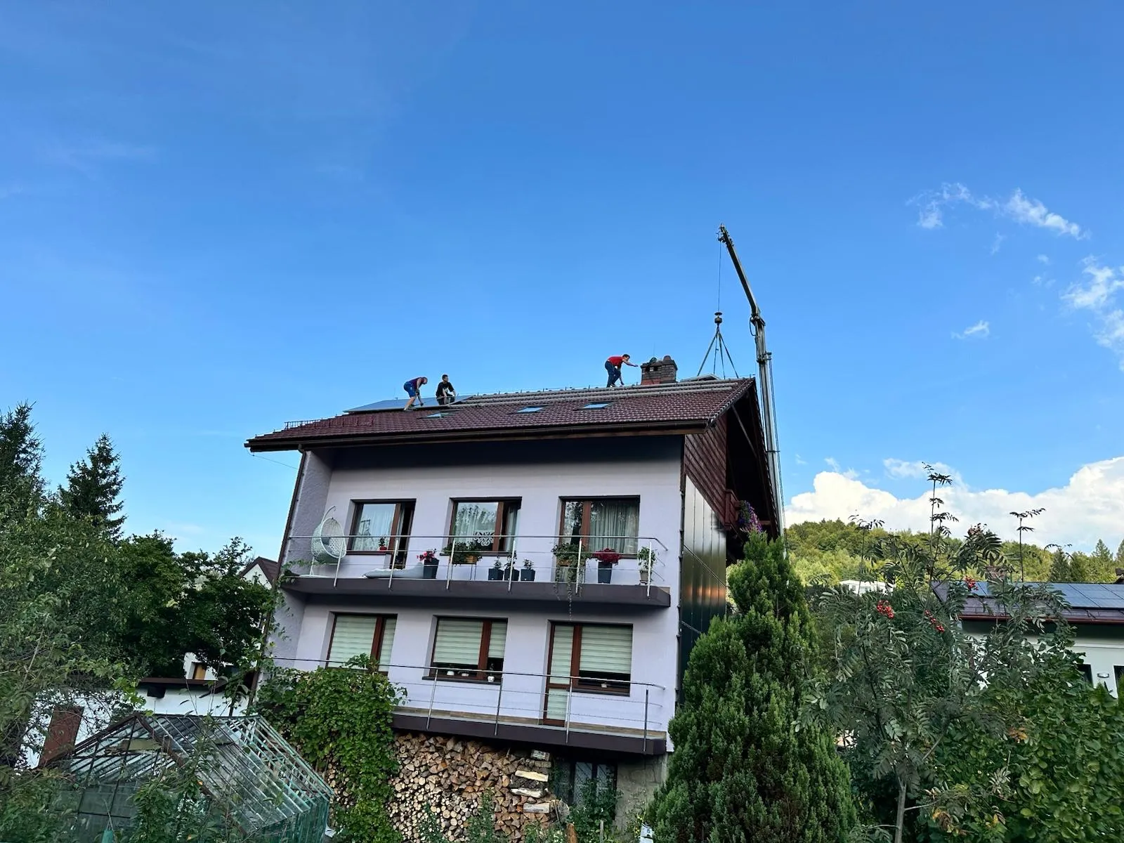 Dom jednorodzinny podczas prac dachowych wspieranych przez dźwig.