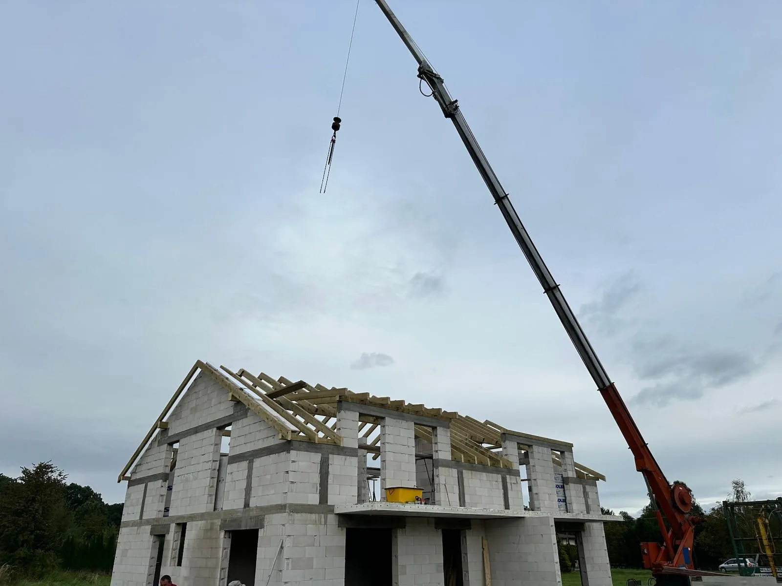 Front budynku z czytelnym układem głównych elementów konstrukcji dachowej.