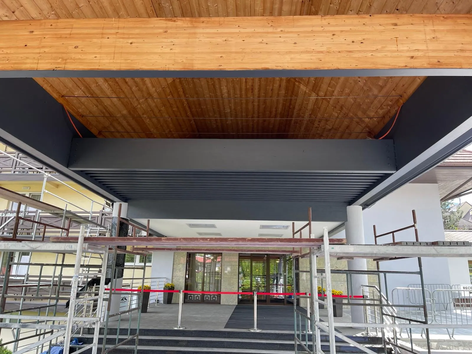 Gotowe wejście główne z nowym zadaszeniem, które porządkuje i wzmacnia reprezentacyjny charakter obiektu.