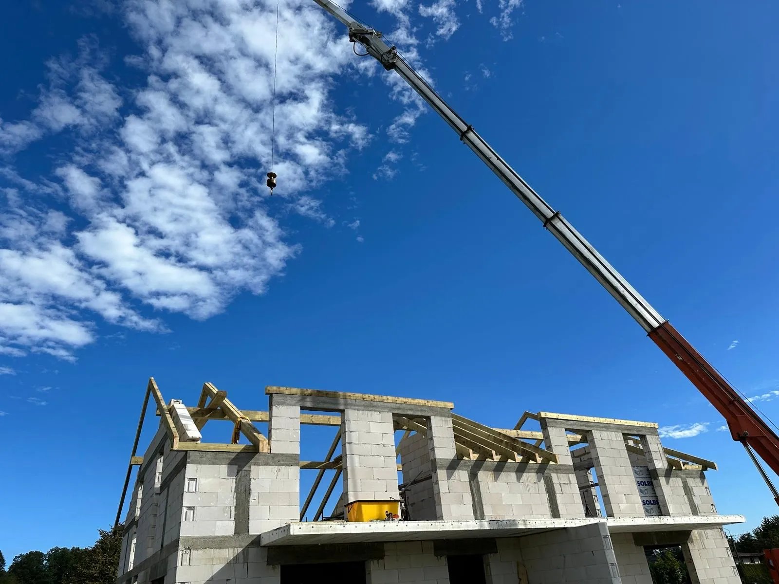 Praca dźwigu podczas montażu elementów więźby, która usprawnia tempo i bezpieczeństwo robót.