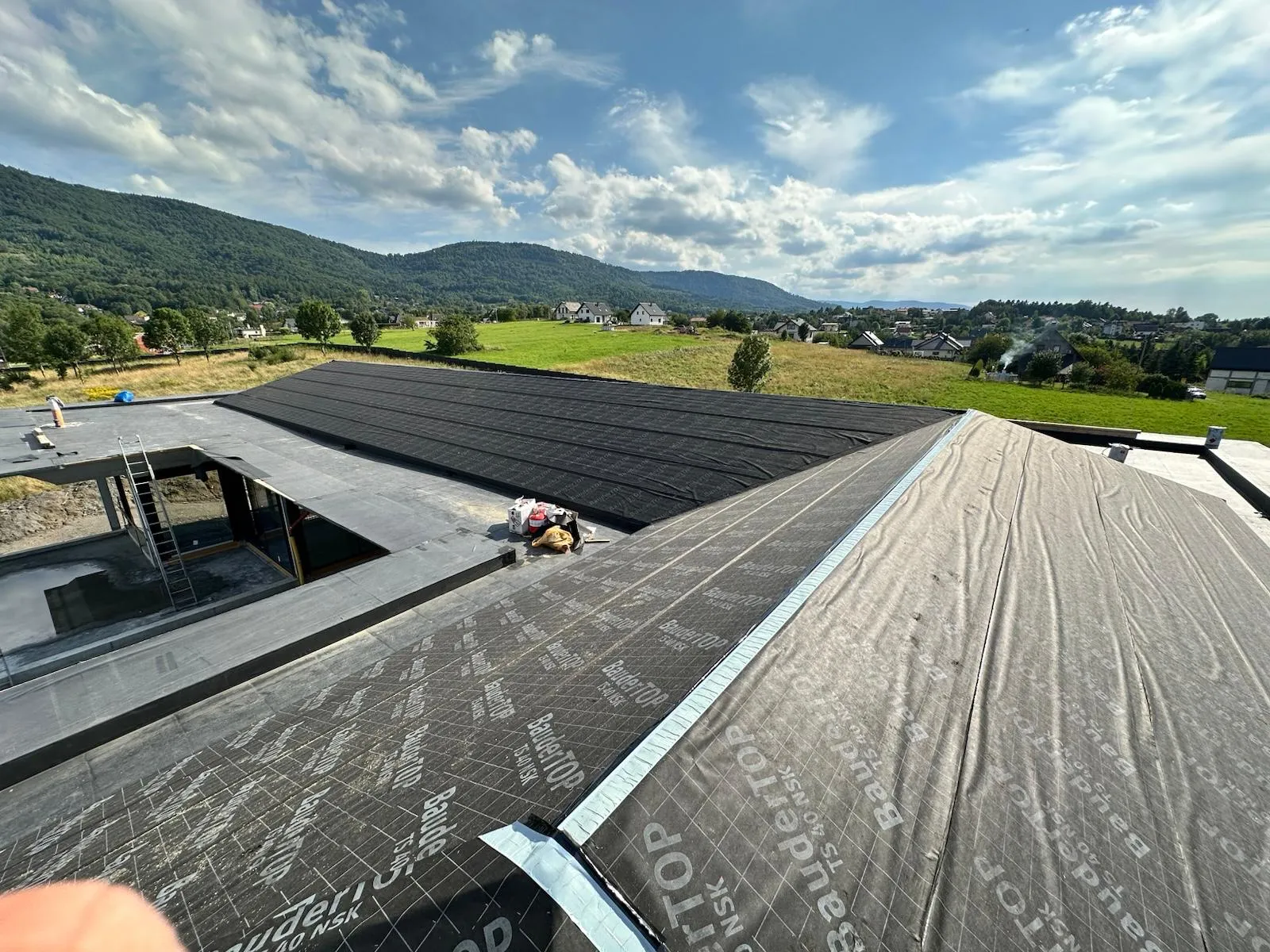 Duże połacie dachowe zabezpieczone membraną przed montażem kolejnych warstw.