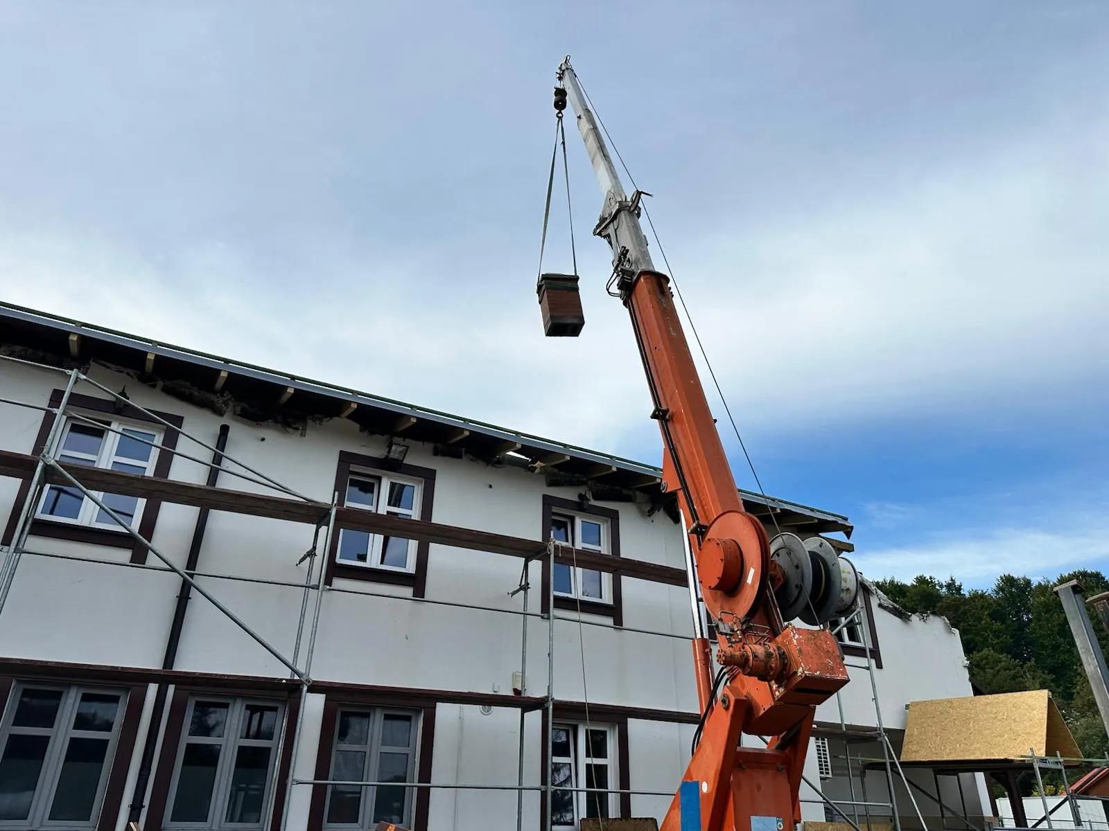 Dźwig podający materiał na dach, co usprawnia prowadzenie prac remontowych na wysokości.