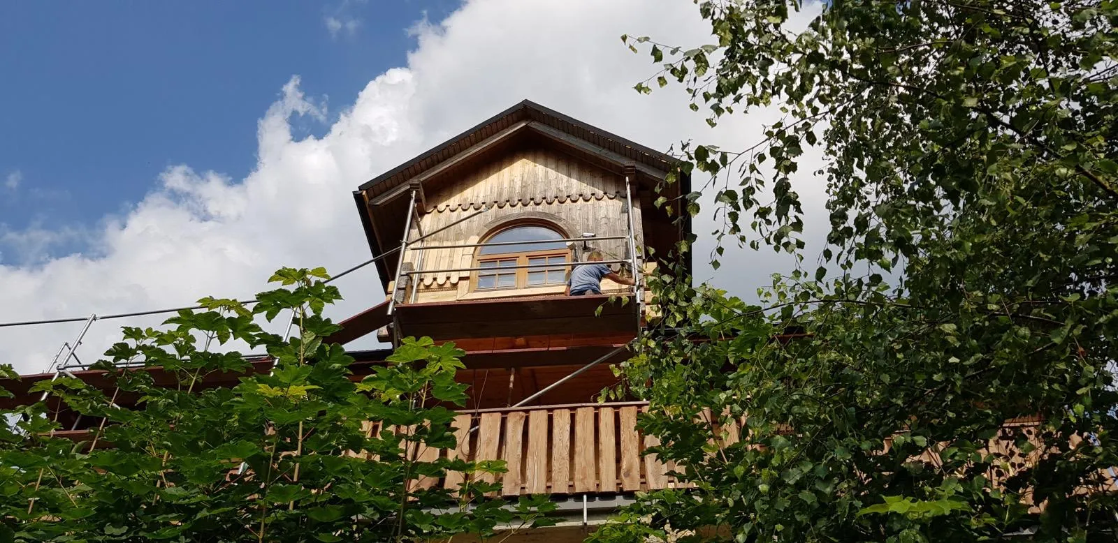 Front budynku z widocznymi uszkodzeniami w obrębie dachu i okapu.