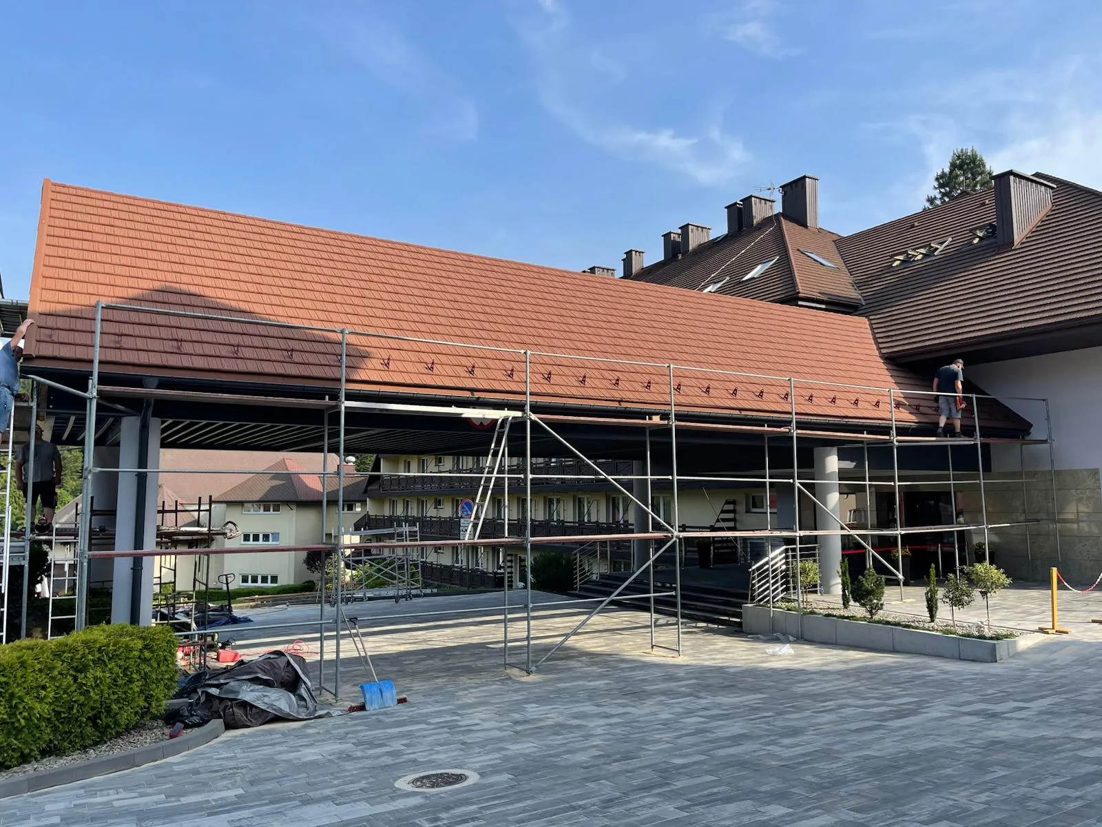 Zadaszenie wejścia na etapie końcowego wykończenia i porządkowania strefy frontowej.