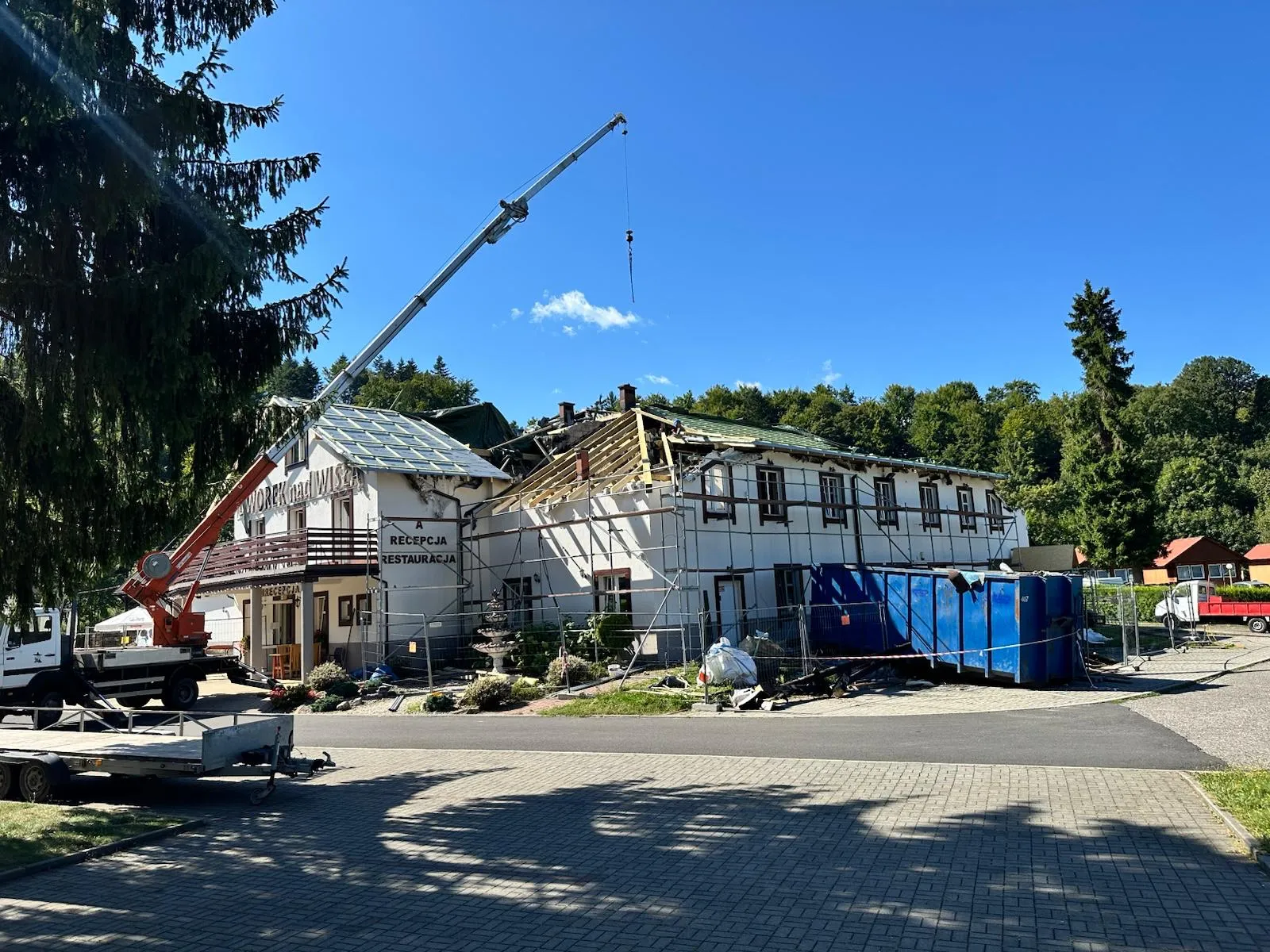 Obiekt po pożarze z przygotowanym frontem robót i dźwigiem wspierającym remont dachu.